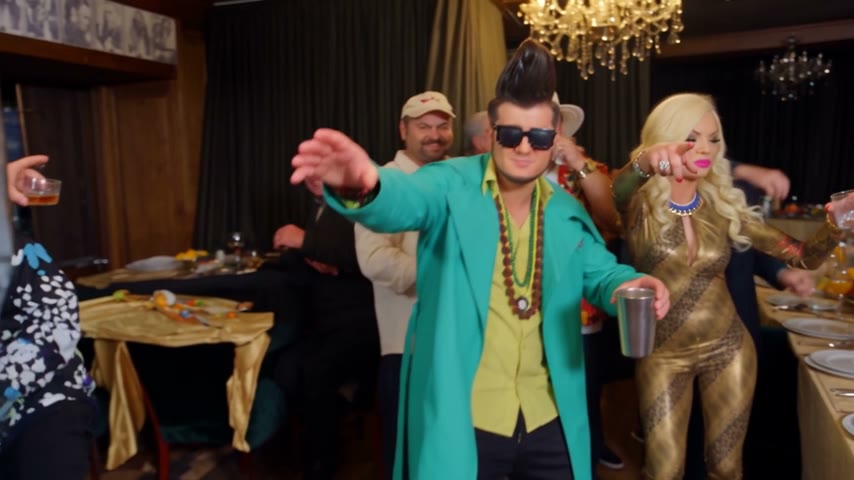Burning Bridges AI AI party video reference: a performer in a green blazer at a chandelier party.